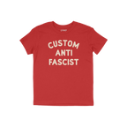 Custom Anti-Fascist Kids T-shirt featuring bold, off-white CUSTOM ANTI FASCIST text on a red short-sleeve. Ideal for young ac