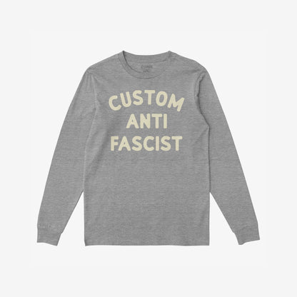 Heather-gray long-sleeve T-shirt with CUSTOM ANTI FASCIST in cream block letters, allowing customization of Custom. Ideal for cooler days and activism, promoting equality and anti-fascism.
