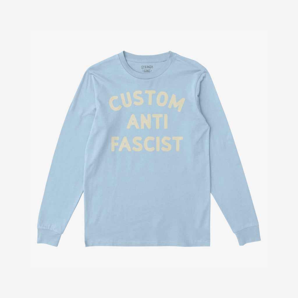 Custom Anti-Fascist Long Sleeve T-shirt with CUSTOM ANTI FASCIST printed in off-white. A platform for personal expression, ideal for cooler days or activism, aligning with the store's advocacy for equality.