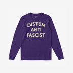 Custom Anti-Fascist Long Sleeve T-shirt featuring CUSTOM ANTI FASCIST in off-white block letters on deep purple, ideal for activism and expression. Personalize with your city or message.