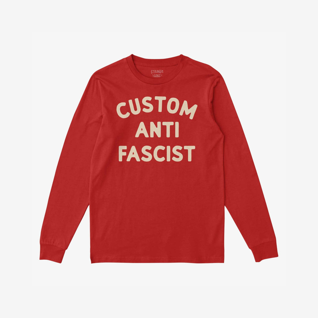 Custom Anti-Fascist Long Sleeve T-shirt laid flat, featuring bold cream text CUSTOM ANTI FASCIST on soft red fabric, inviting personalization for activism and expression.