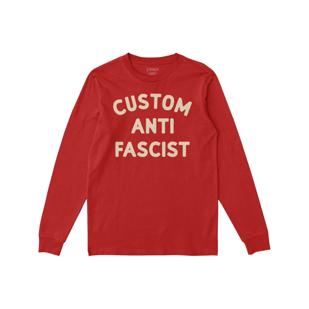 Custom Anti-Fascist Long Sleeve T-shirt laid flat, featuring bold cream text CUSTOM ANTI FASCIST on soft red fabric, inviting
