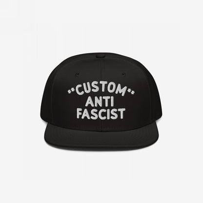 Custom Anti-Fascist Snapback Hat with bold white embroidery on a black flat-brimmed cap, featuring adjustable closure. Personalize the Custom text, showcasing your stance against fascism with style and comfort.