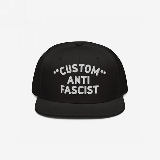 Custom Anti-Fascist Snapback Hat with bold white embroidery on a black flat-brimmed cap, featuring adjustable closure. Personalize the Custom text, showcasing your stance against fascism with style and comfort.