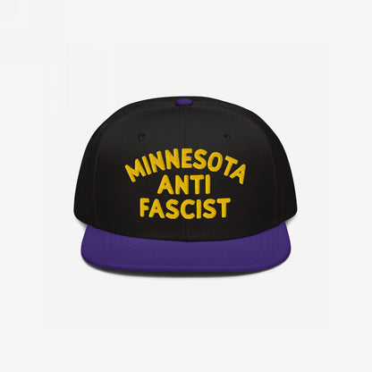Custom Anti-Fascist Snapback Hat featuring bold yellow MINNESOTA ANTI FASCIST embroidery on the front. Black crown, purple flat brim, adjustable closure, promoting equality and anti-fascism with customizable city or community text.