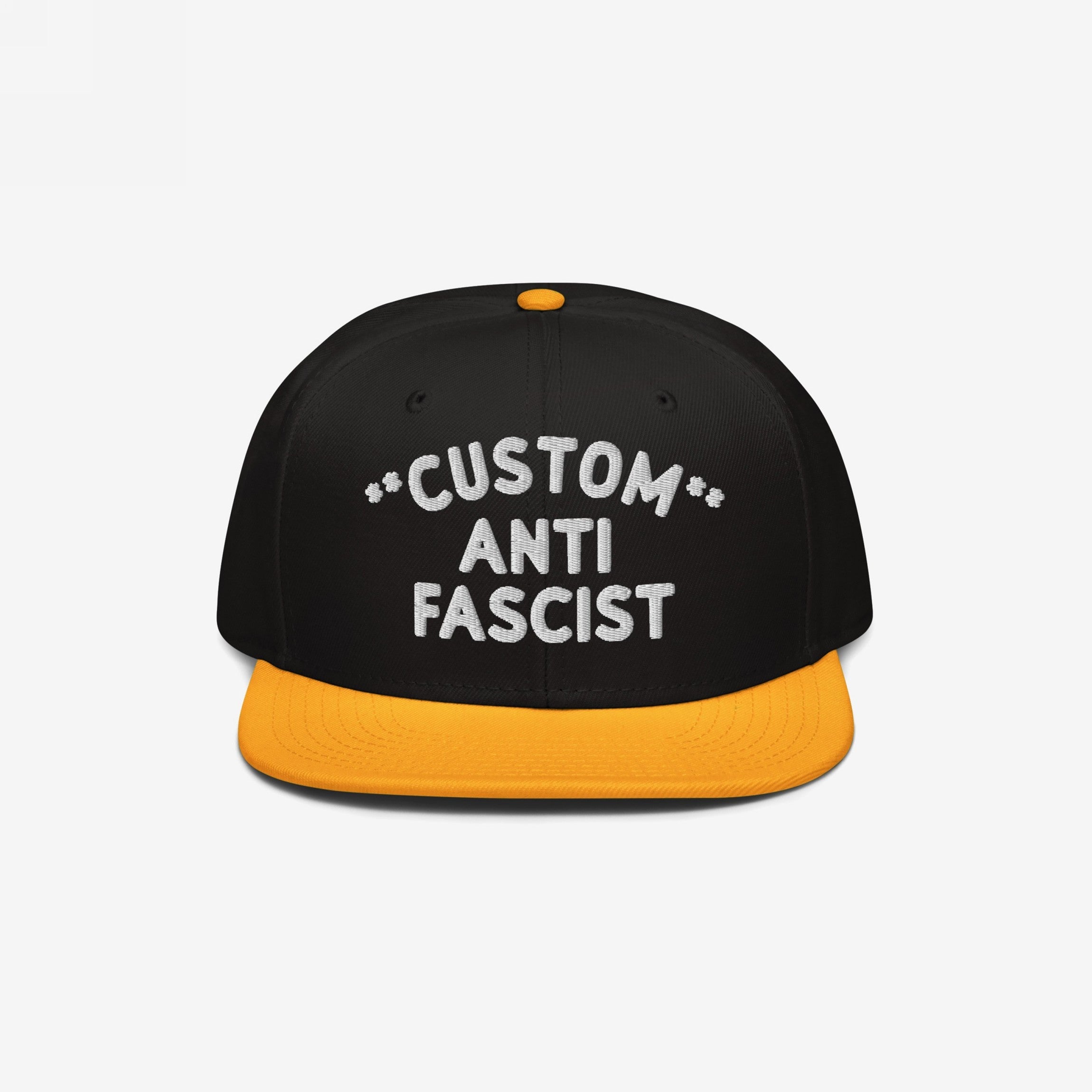 Custom Anti-Fascist Snapback Hat featuring a black crown and yellow brim, with bold white CUSTOM ANTI FASCIST embroidery. Personalize the Custom text to reflect your values. Adjustable fit, structured design.