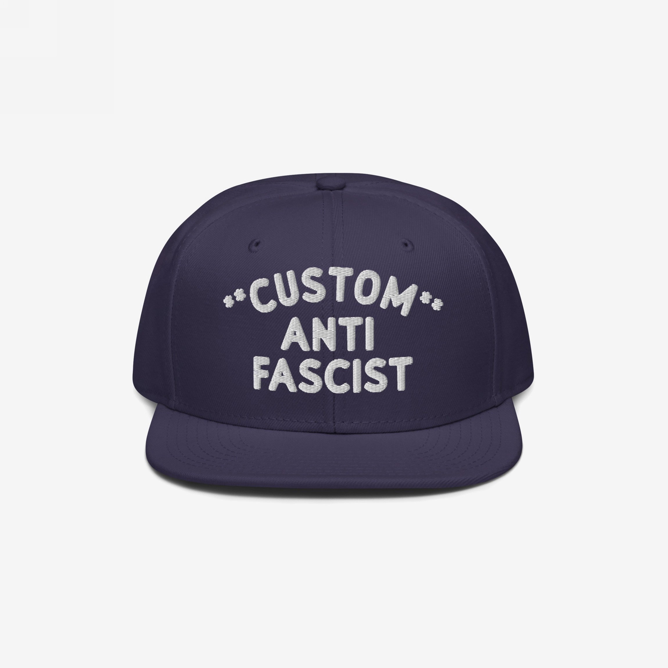 Custom Anti-Fascist Snapback Hat featuring a navy flat-brim design with bold white embroidery. The adjustable snapback offers a customizable anti-fascist message, blending comfort and style for supporters of equality.