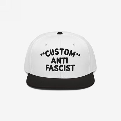 Custom Anti-Fascist Snapback Hat with bold text, featuring a white crown and black visor. Personalize the Custom text for a unique anti-fascist statement. Structured design with adjustable closure for comfort.