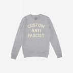 Custom Anti-Fascist Sweatshirt featuring bold cream text, highlighting personal values. Midweight crewneck design ideal for protests or daily wear, inviting personalization on the Custom text for individual expression.