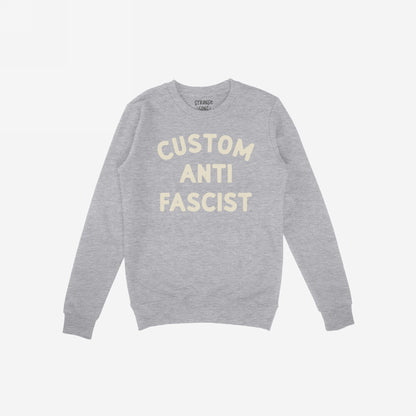 Custom Anti-Fascist Sweatshirt featuring bold cream text, highlighting personal values. Midweight crewneck design ideal for protests or daily wear, inviting personalization on the Custom text for individual expression.