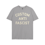 Heather-gray T-shirt with “CUSTOM ANTI FASCIST” in off-white letters, showcasing a strong statement. The neck label reads