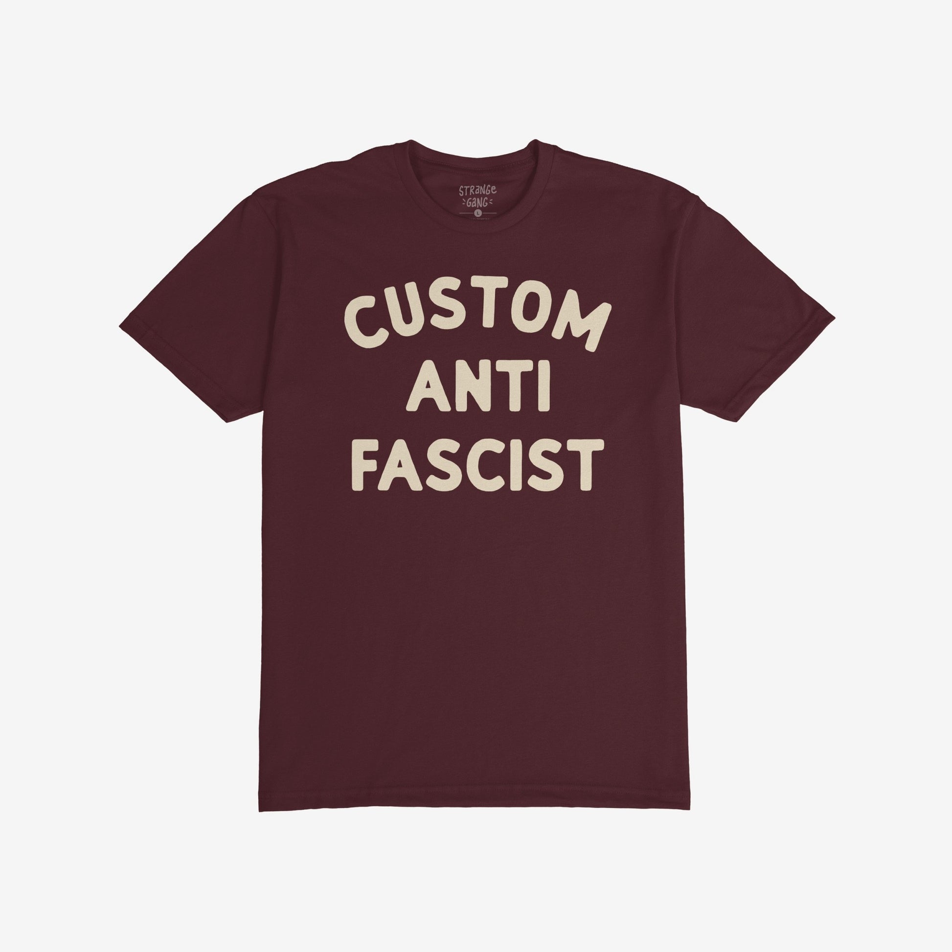 Custom Anti-Fascist T-shirt featuring bold cream text CUSTOM ANTI FASCIST on a maroon crew-neck, embodying a strong anti-fascism message. Ideal for activism and everyday wear.
