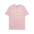 Light pink Custom Anti-Fascist T-shirt with bold off-white text on the chest, designed for personalization, promoting anti-fa
