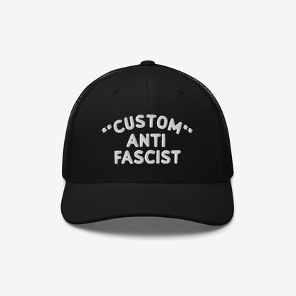 Black mesh-back trucker cap with curved visor, featuring CUSTOM ANTI FASCIST. embroidered in white. Personalize the Custom text. Breathable and adjustable, embodying bold anti-fascist messaging with style and comfort.