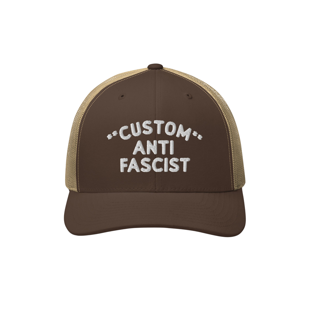 Brown-and-tan trucker cap with mesh back, featuring white embroidered CUSTOM ANTI FASCIST text, highlighting personalizable d