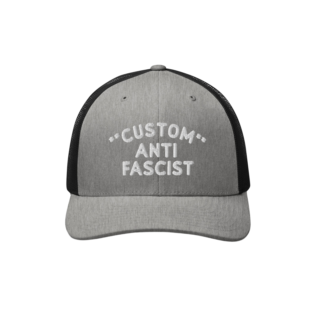 Custom Anti-Fascist Trucker Hat with light gray front, black mesh back, and white embroidered message. Features breathable me