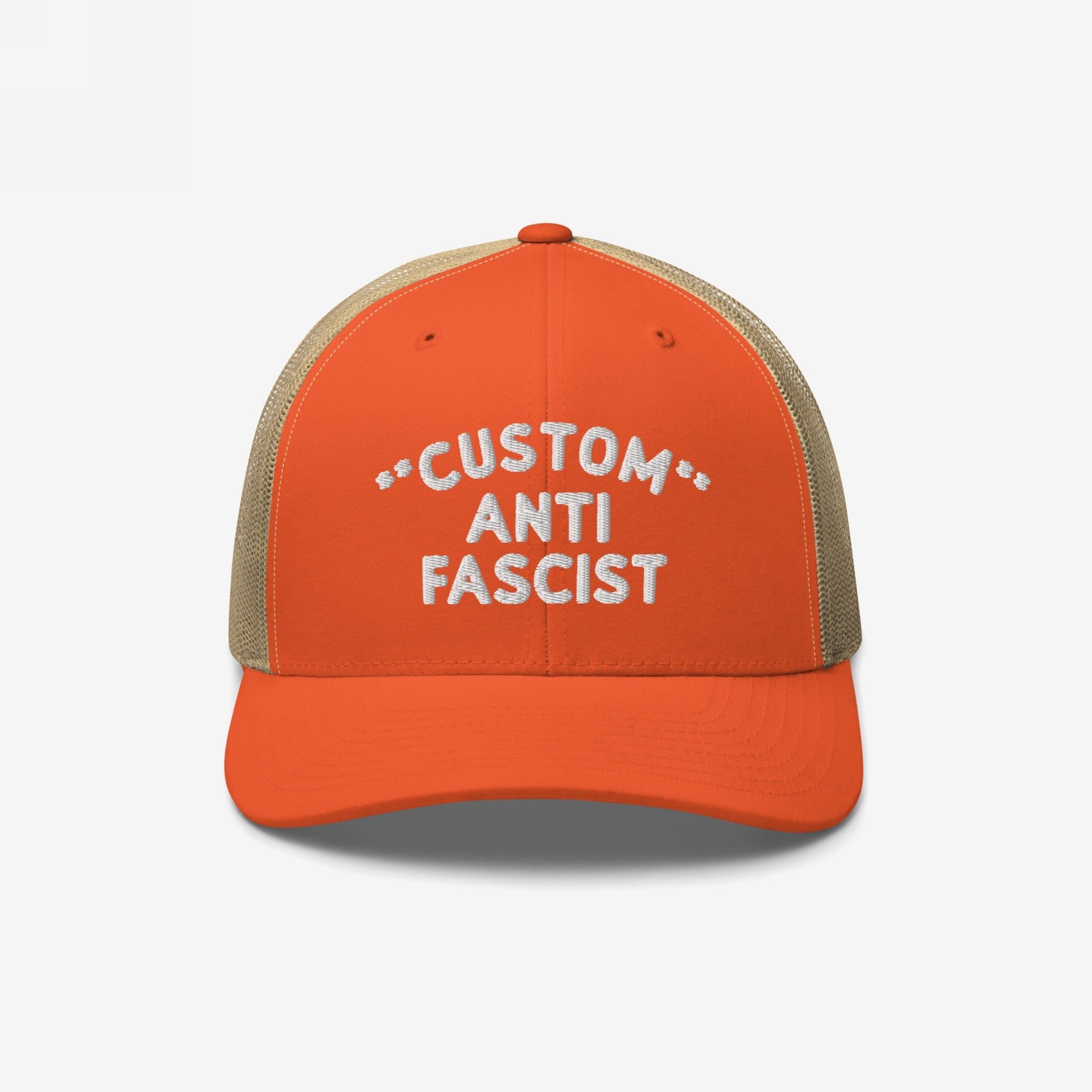 The Custom Anti-Fascist Trucker Hat features bright orange front panels with CUSTOM ANTI FASCIST embroidered in white, a breathable khaki mesh back, and adjustable snap closure for comfort and style.