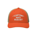 The Custom Anti-Fascist Trucker Hat features bright orange front panels with CUSTOM ANTI FASCIST embroidered in white, a brea
