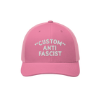 Custom Anti-Fascist Trucker Hat features a pink design with white CUSTOM ANTI FASCIST embroidery. The hat includes mesh panel