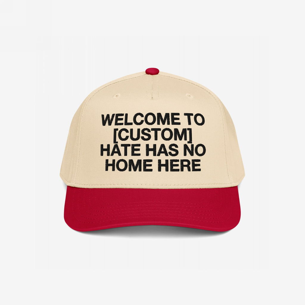 Custom Hate Has No Home Here 5-Panel Hat featuring a beige crown and red brim, with bold black lettering promoting unity and inclusion, customizable with your city name.