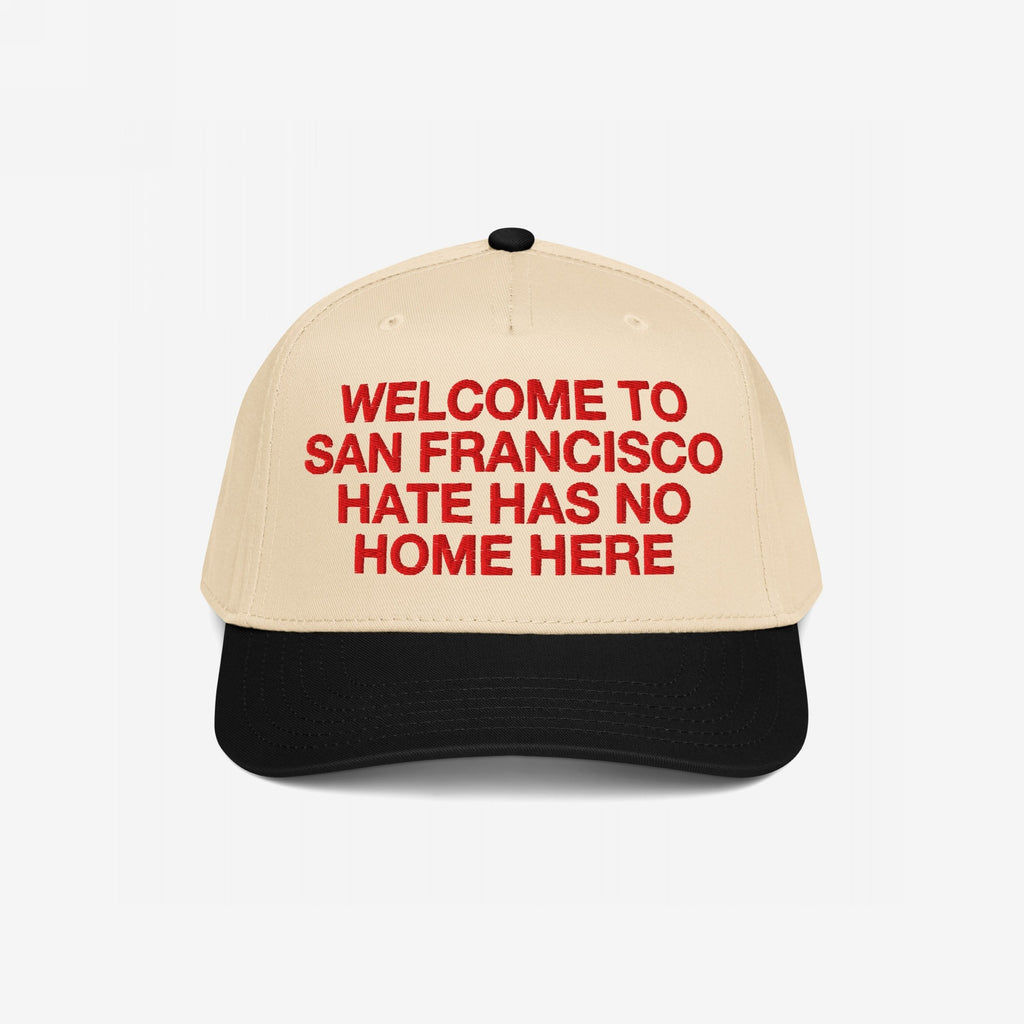 Custom Hate Has No Home Here 5-Panel Hat featuring a beige crown with bold red embroidery reading WELCOME TO SAN FRANCISCO HATE HAS NO HOME HERE and a black visor, embodying unity and inclusivity.