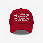 Red Custom Hate Has No Home Here Dad Hat with white embroidered text, promoting inclusion. Features an adjustable strap, curved brim, and subtle back logo, embodying a bold stance against hate.