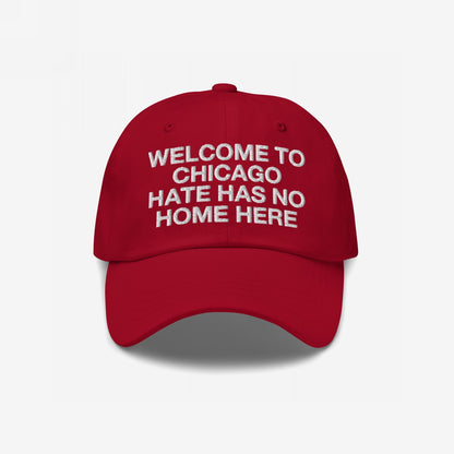Red Custom Hate Has No Home Here Dad Hat with white embroidered text, promoting inclusion. Features an adjustable strap, curved brim, and subtle back logo, embodying a bold stance against hate.