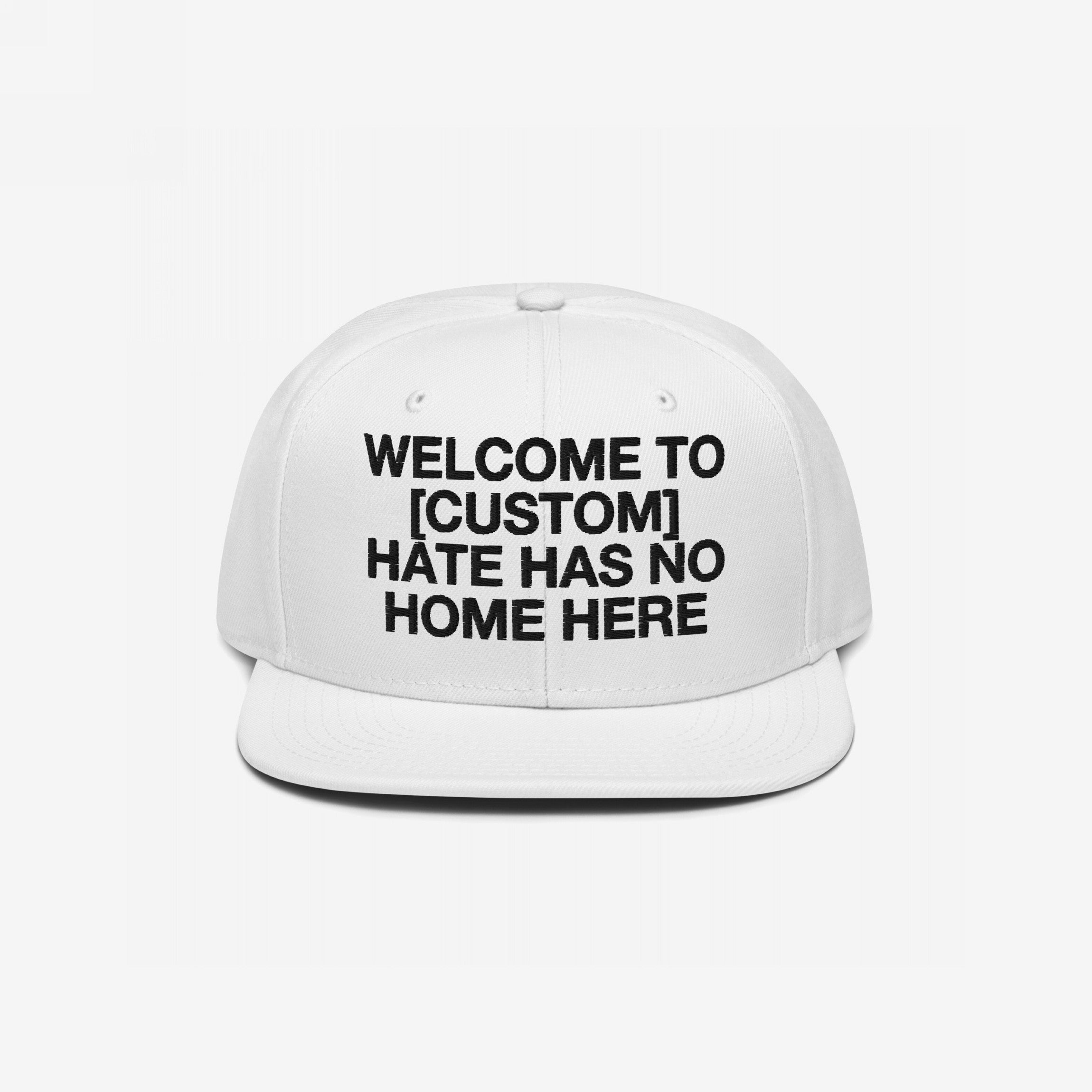 Custom Hate Has No Home Here Snapback Hat featuring bold black lettering on the front panel. Personalize with your city name to express unity and anti-hate values.