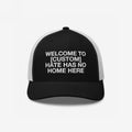 Custom Hate Has No Home Here Trucker Hat with a black front and white mesh back, featuring an embroidered message promoting community values and inclusion.