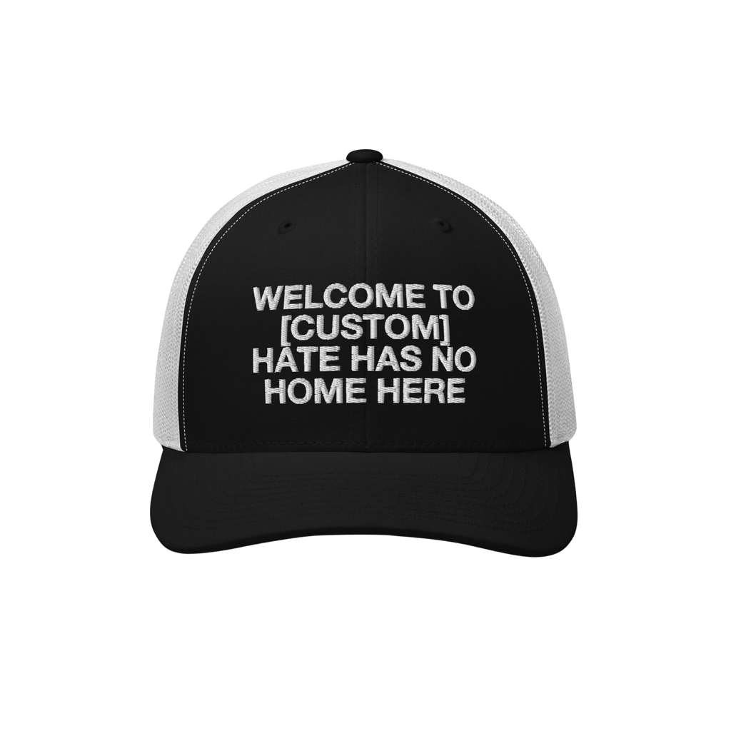 Custom Hate Has No Home Here Trucker Hat with a black front and white mesh back, featuring an embroidered message promoting c