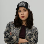 Young woman wearing a Custom Hate Has No Home Here Trucker Hat with a bold slogan, paired with a patterned bomber jacket and burgundy top, exuding confidence and solidarity against hate.