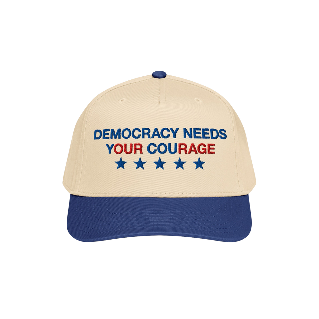 Two-tone Democracy Hat with beige front, blue bill. Embroidered “DEMOCRACY NEEDS YOUR COURAGE” in blue and red, with five