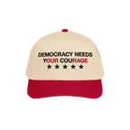 Democracy Hat with a beige crown and red bill, featuring “DEMOCRACY NEEDS YOUR COURAGE” in bold embroidery, ideal for sho