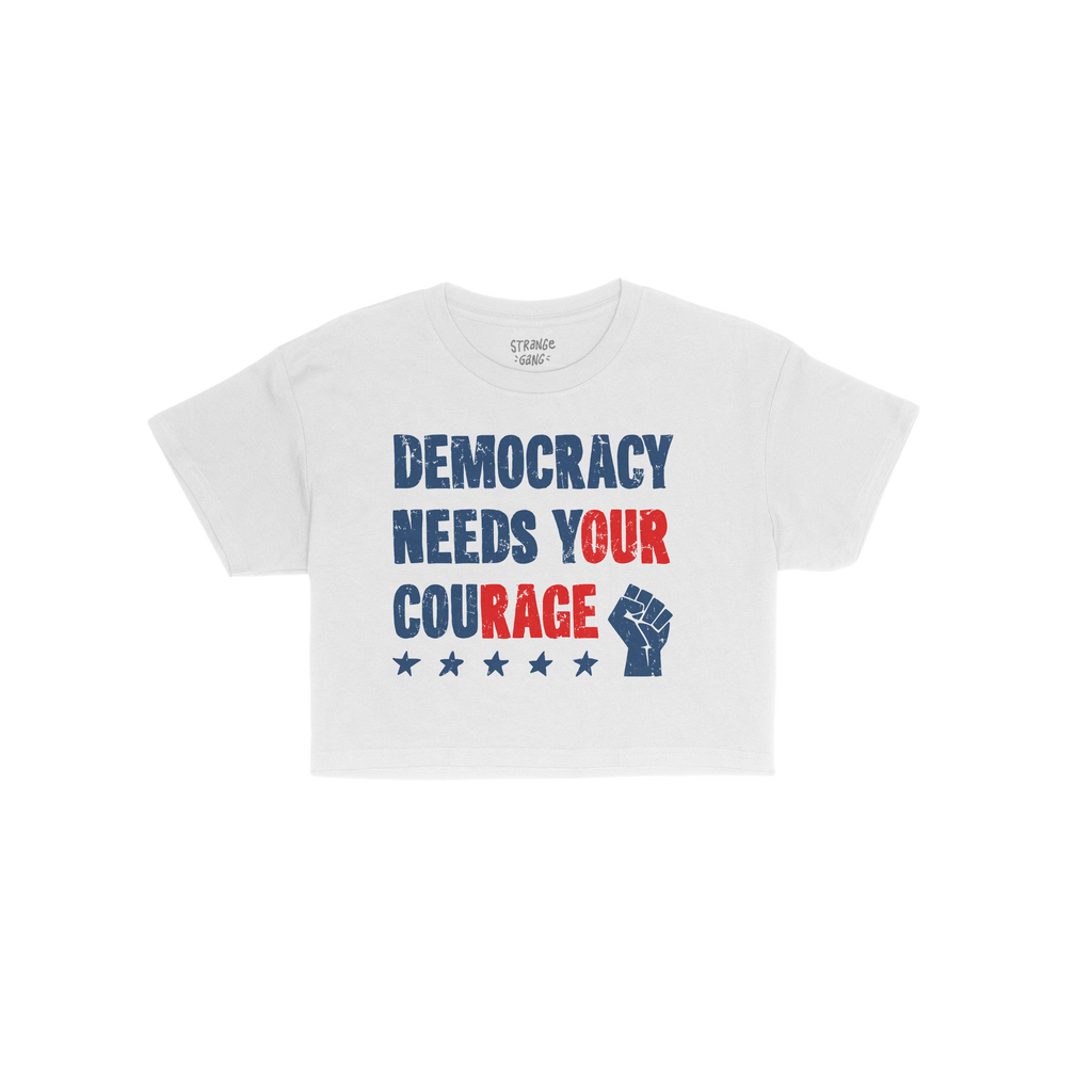 Democracy Women's Baby Tee features a bold, distressed slogan DEMOCRACY NEEDS YOUR COURAGE with a raised fist and five stars,