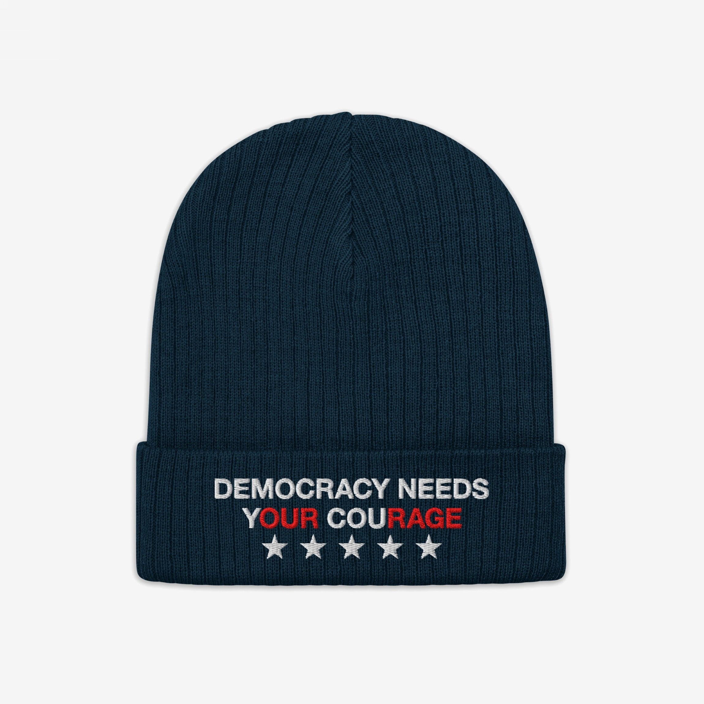 Democracy Hat: A dark-navy ribbed knit beanie featuring “DEMOCRACY NEEDS YOUR COURAGE” embroidered on the cuff, emphasizing Our Rage, with five white stars, embodying anti-fascist and equality values.