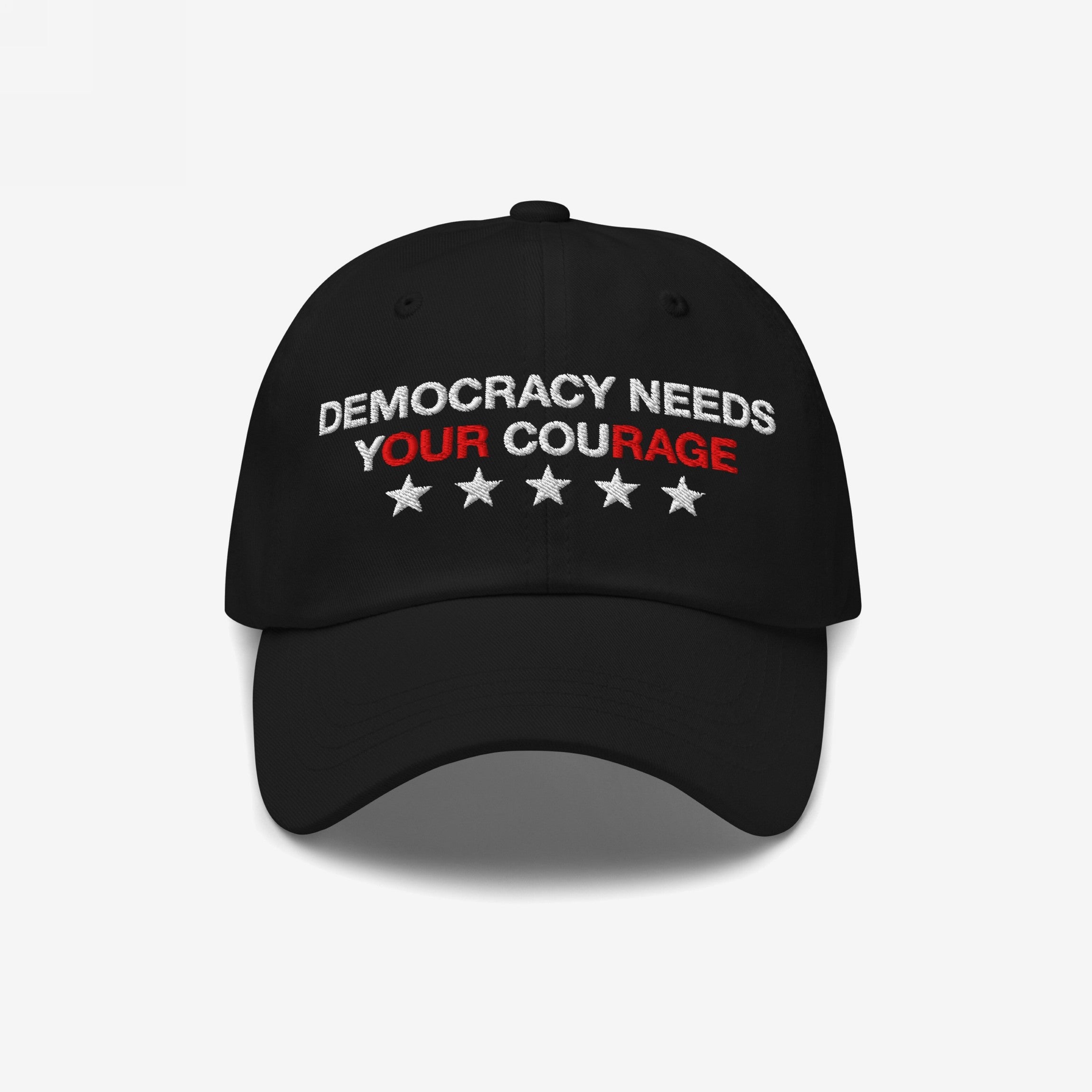 Democracy Hat featuring DEMOCRACY NEEDS YOUR COURAGE embroidered in white and red on a black six-panel cap, with five white stars below, symbolizing resistance and activism.