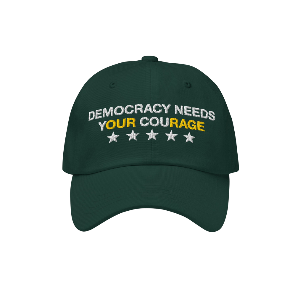 Dark green Democracy Hat with white embroidery: DEMOCRACY NEEDS YOUR COURAGE, highlighting YOUR in yellow, plus five stars be