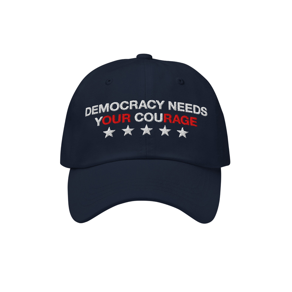 Navy blue Democracy Hat with “DEMOCRACY NEEDS YOUR COURAGE” embroidered on the front, highlighting YOUR COURAGE in red, c