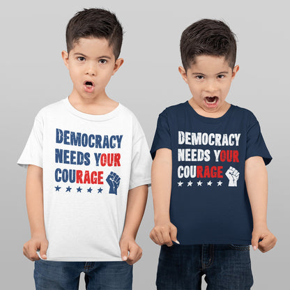 Two boys showcase the Democracy Shirt, featuring a bold slogan Democracy Needs Your Courage with a raised fist icon, embodying a message of protest and empowerment.