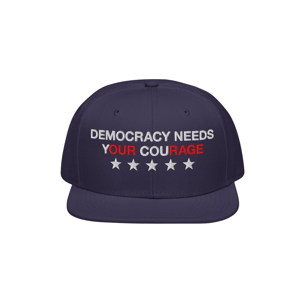 Navy-blue Democracy Hat with flat brim, embroidered with “Democracy Needs Your Courage” and stars, representing a bold an