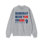 The Democracy Shirt features bold, distressed lettering with the slogan DEMOCRACY NEEDS YOUR COURAGE and a raised-fist icon, 