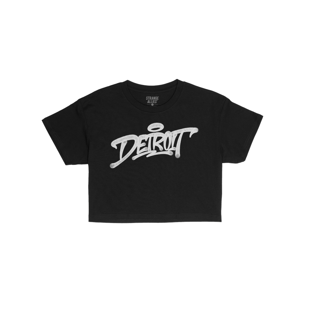 Detroit Handstyle Women's Baby Tee featuring bold white graffiti-style DETROIT script with a halo flourish, laid flat. Perfec