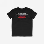 Don't Be Complicit T-shirt, featuring a bold protest slogan on the back, laid flat. The design advocates against injustice, perfect for those supporting equality and human rights.
