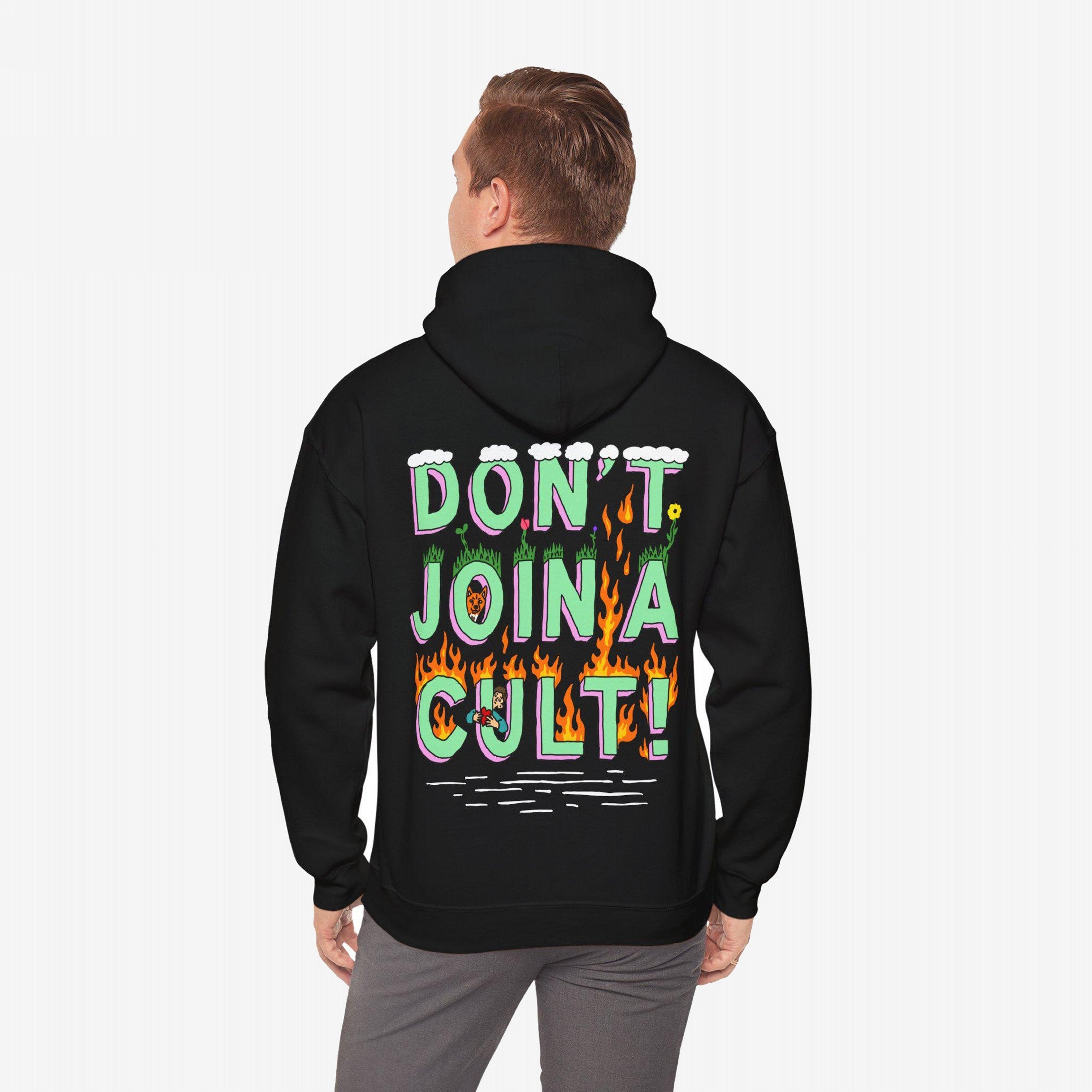 A person wears the Don't Join A Cult Shirt, featuring bold, multicolor text with cloud, grass, and flame motifs, embodying a progressive message for activism and awareness.
