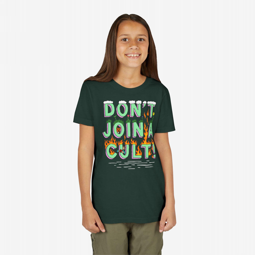 Young girl smiling, wearing the Don't Join A Cult T-shirt with colorful lettering, grass patches, and flames, embodying a bold, progressive message. Arms relaxed, perfect for rallying or casual wear.