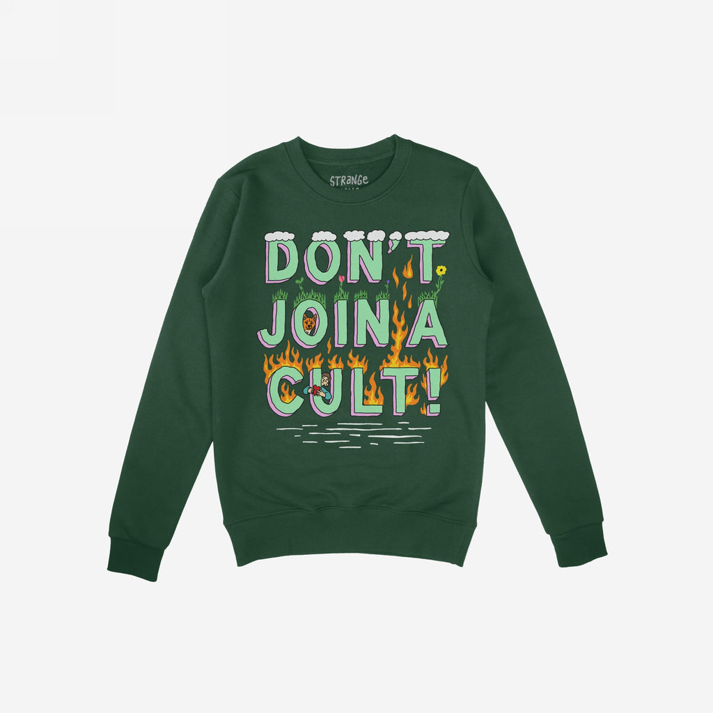 Dark-green Don't Join A Cult Shirt with bold, playful lettering and whimsical graphics, conveying a progressive message. Features include grass, flames, and small characters, reflecting a stand against conformity.