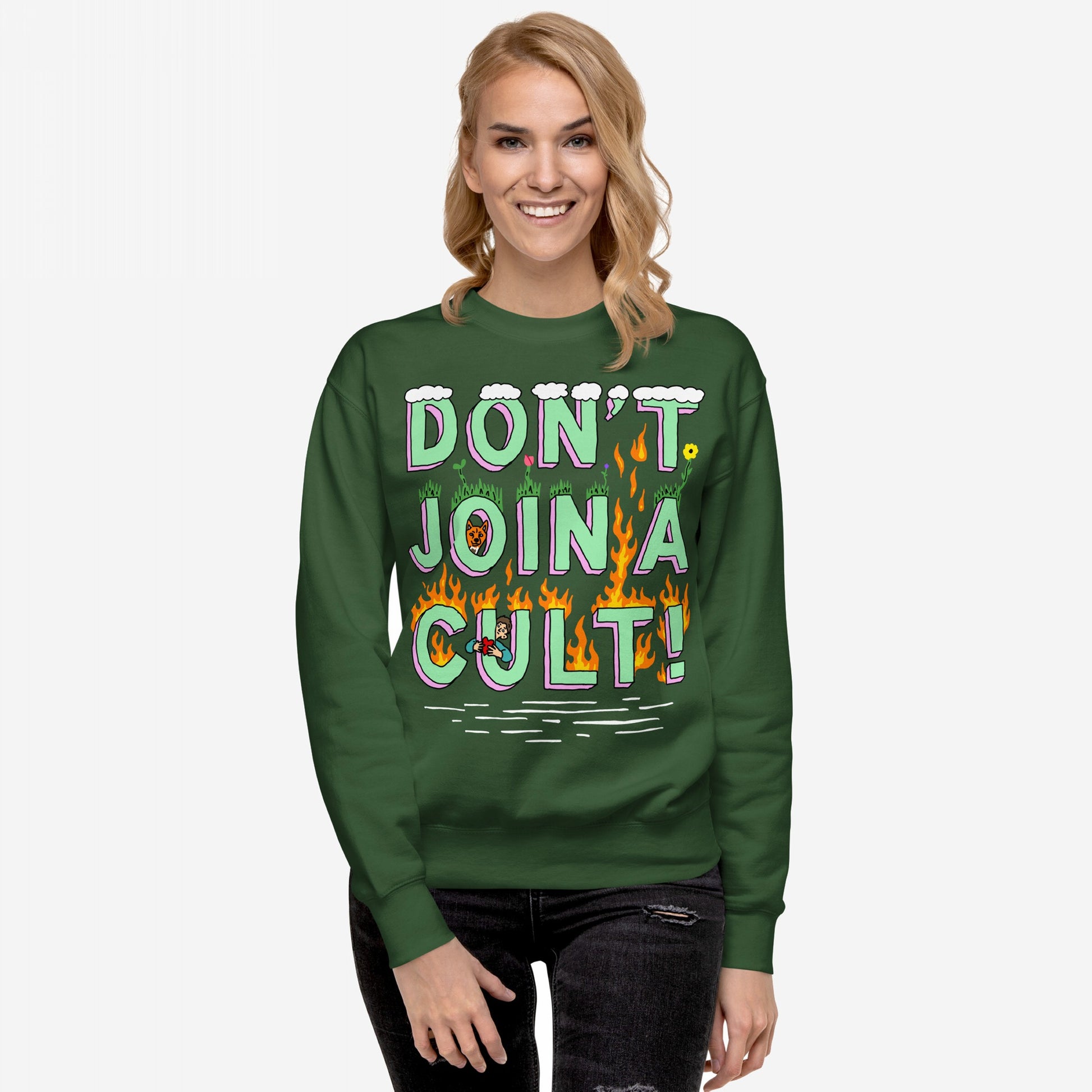 Don't Join A Cult Hoodie & Sweatshirt features a playful yet bold slogan with grass and flames, worn by a smiling woman, embodying a stand against cult mentality and authoritarianism.