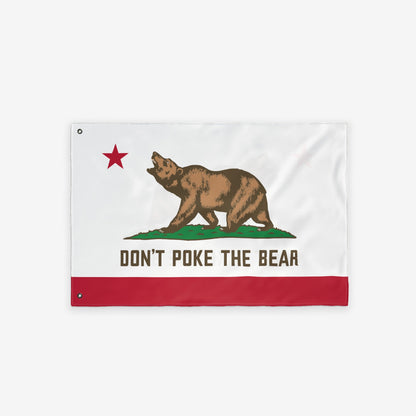 California Don't Poke The Bear Flag features a grizzly on green grass with a red star, bold text, and stripe, symbolizing defiance against authoritarianism. It's lightweight, double-sided, and weather-ready.