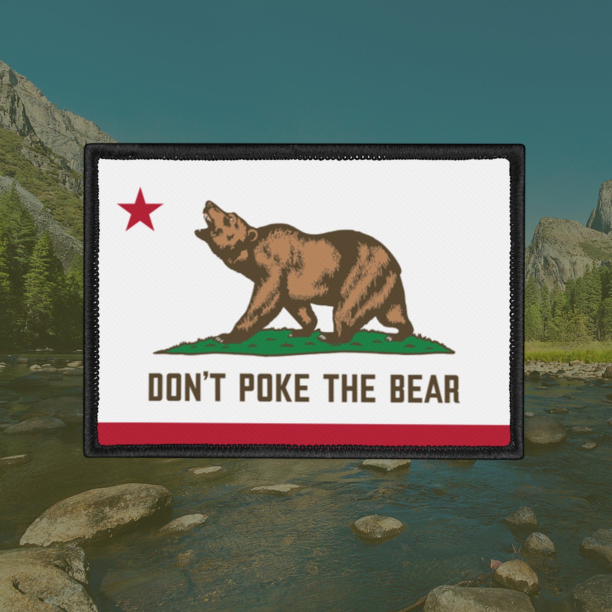 California Don't Poke The Bear Flag Patch features a bear on a grassy mound with a bold message, outlined in black stitching, symbolizing resistance against oppression.