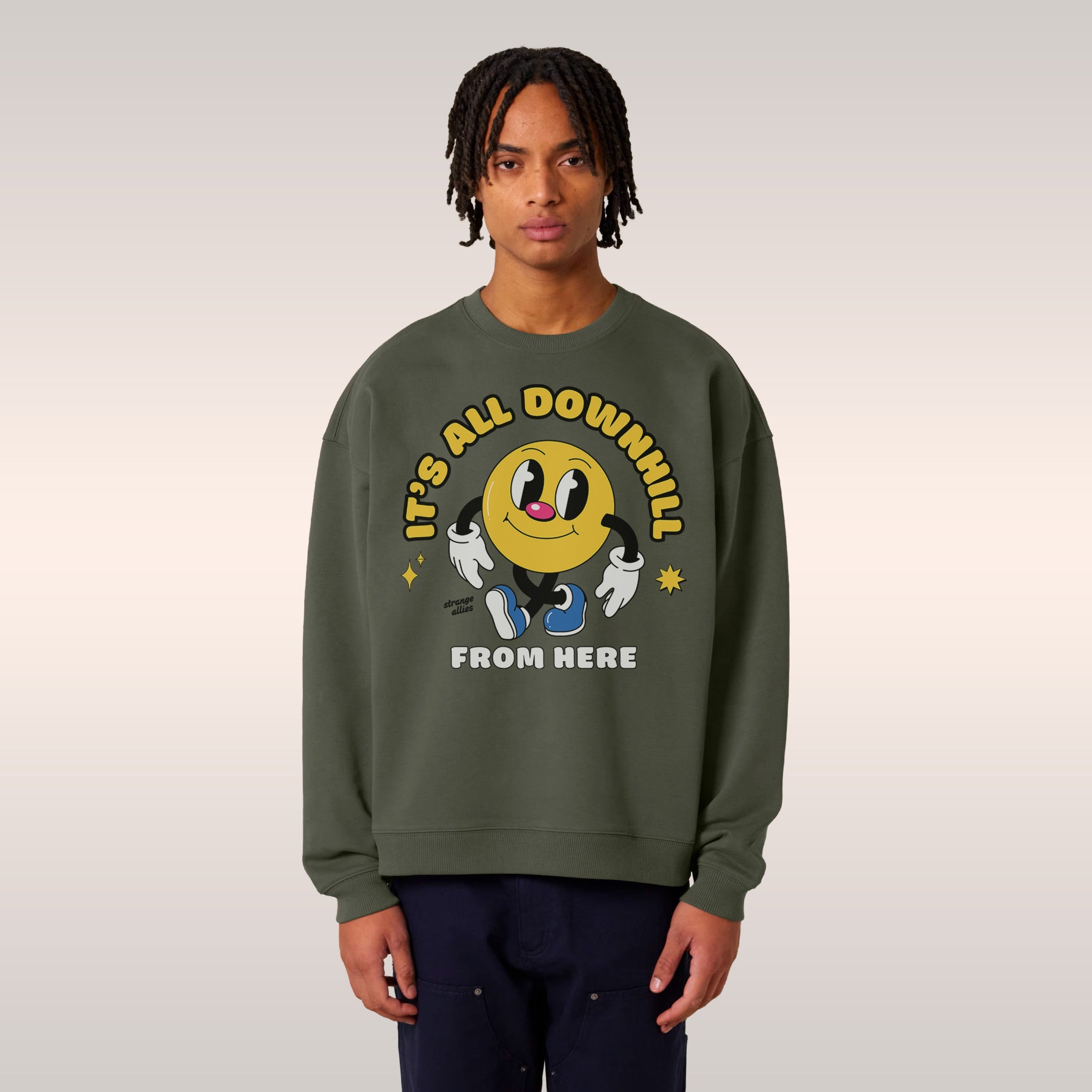 Young person in a bright green Downhill Shirt featuring a yellow smiley-face character with a playful slogan, embodying a che